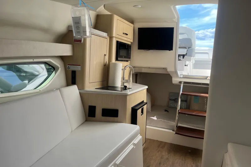  Yacht Photos Pics Interior of 2023 Regal 28 Express boat with kitchenette and seating area.