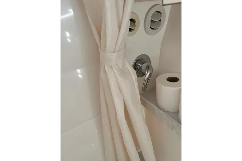  Yacht Photos Pics Bathroom area in 2023 Regal 28 Express boat with shower curtain and toilet paper.