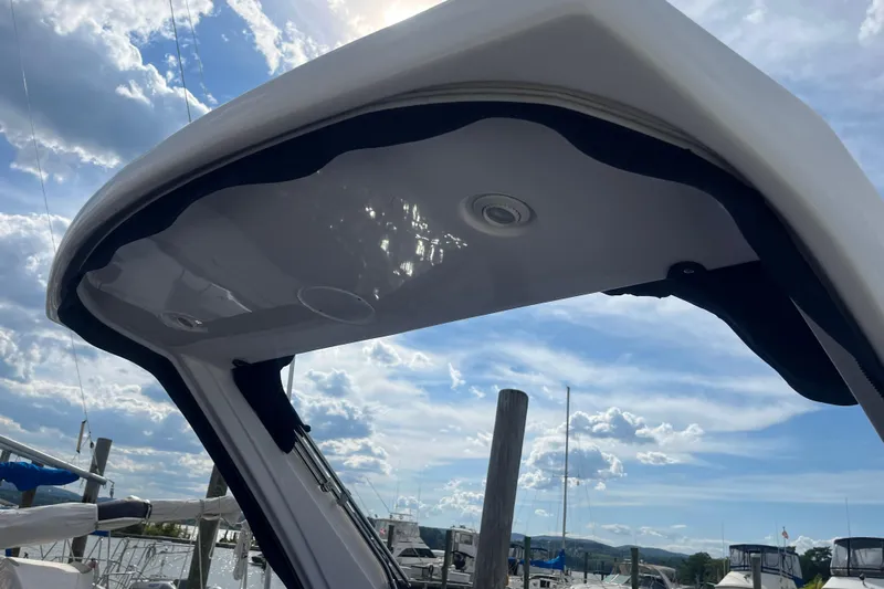  Yacht Photos Pics 2023 Regal 28 Express boat canopy under a bright, partly cloudy sky at a marina.