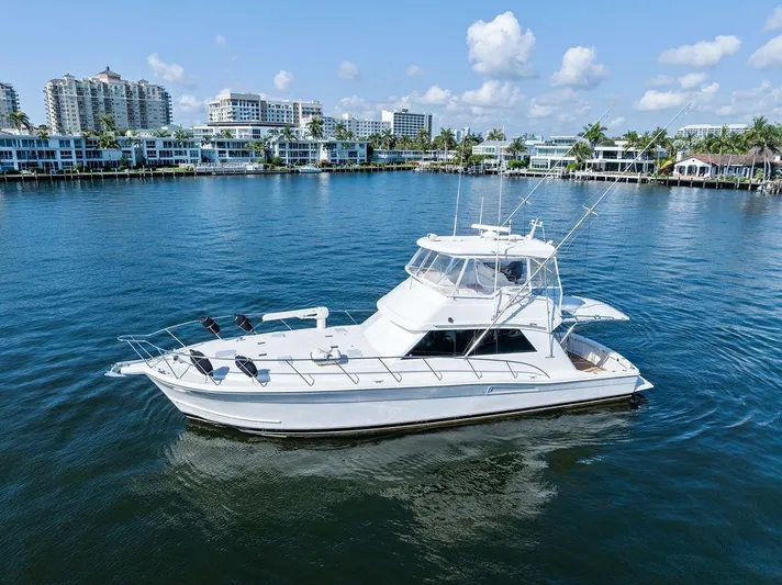  Yacht Photos Pics 2001 Riviera 48 yacht on calm water with cityscape background.