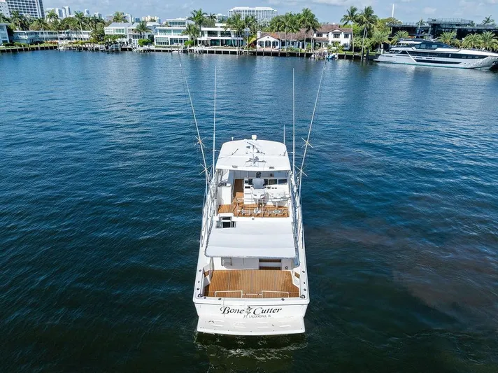  Yacht Photos Pics Riviera 48 yacht from 2001 on calm water, with waterfront homes in the background.