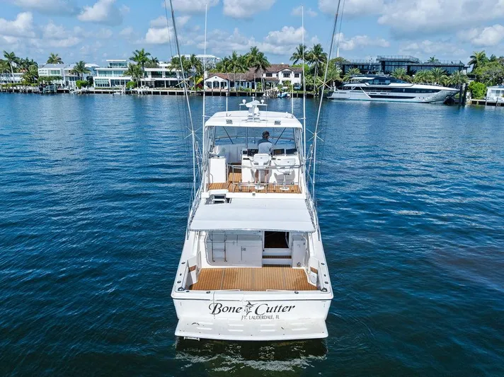  Yacht Photos Pics 2001 Riviera 48 yacht on water, rear view, with coastal homes in the background.