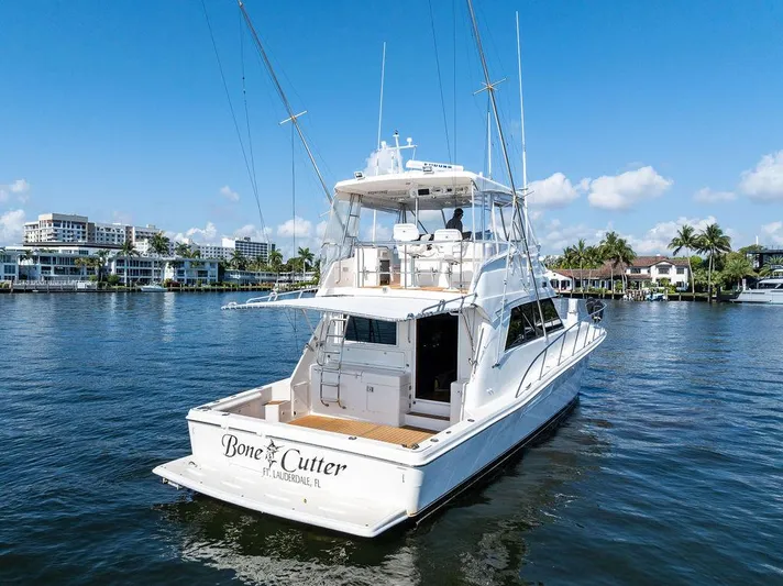  Yacht Photos Pics Riviera 48 yacht from 2001 on a sunny waterfront, featuring a spacious deck.