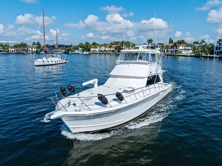  Yacht Photos Pics 2001 Riviera 48 yacht cruising on a sunny day in a scenic harbor.