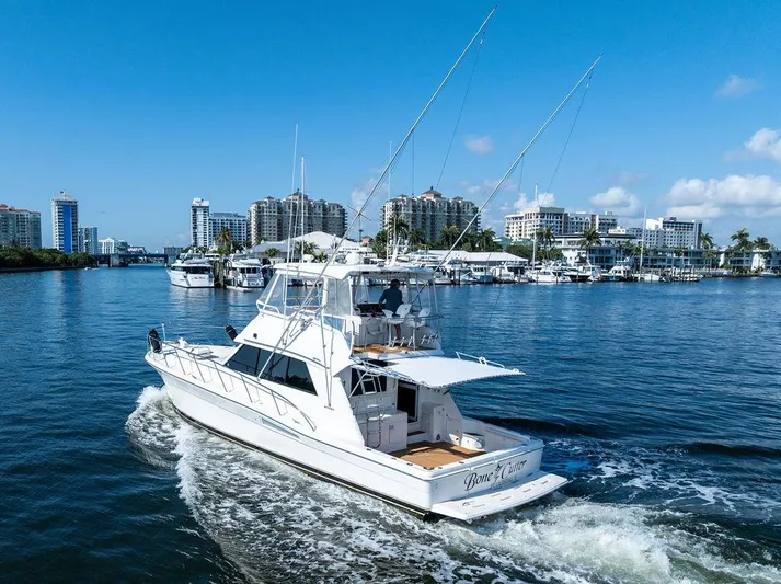  Yacht Photos Pics 2001 Riviera 48 yacht cruising in a scenic urban marina setting.