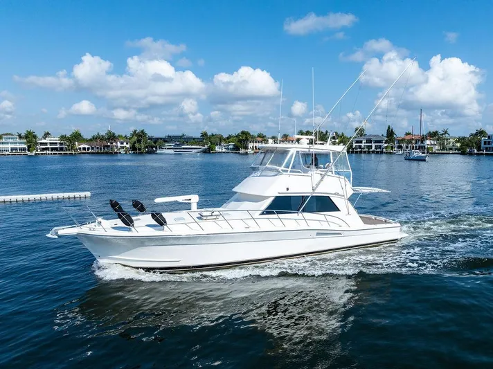  Yacht Photos Pics 2001 Riviera 48 yacht cruising on a sunny day, surrounded by calm waters and blue skies.