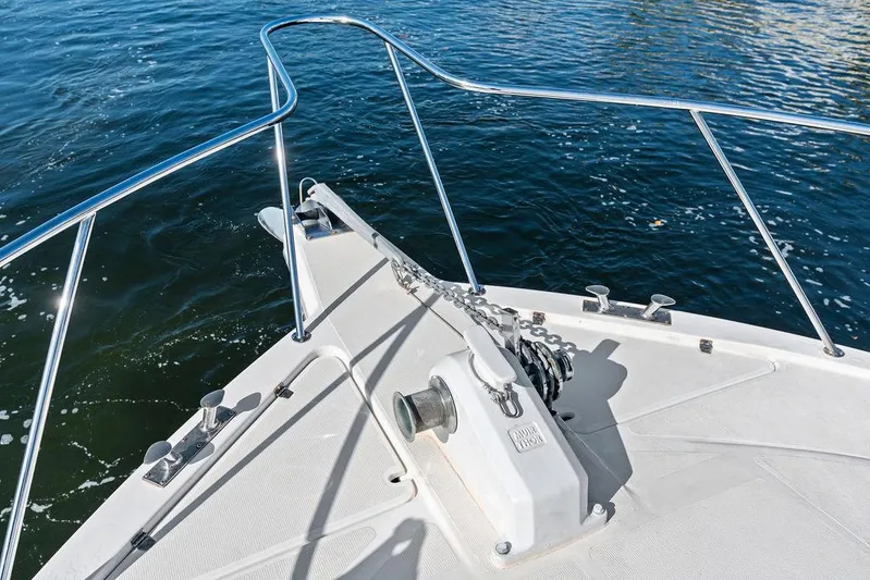  Yacht Photos Pics Bow of 2001 Riviera 48 yacht with anchor and railing on calm water.