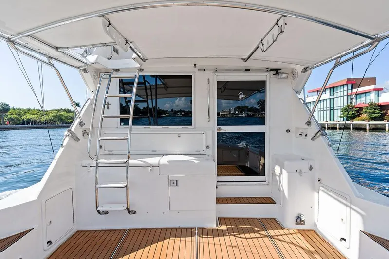  Yacht Photos Pics 2001 Riviera 48 yacht deck with ladder, wooden flooring, and waterfront view.