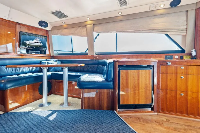  Yacht Photos Pics Luxurious interior of a 2001 Riviera 48 yacht with elegant wood finishes and blue seating.