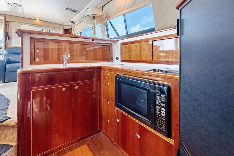  Yacht Photos Pics Luxurious 2001 Riviera 48 yacht kitchen with wood cabinetry and modern appliances.