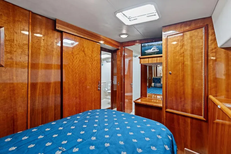  Yacht Photos Pics Luxurious 2001 Riviera 48 yacht cabin with wooden interior and blue bedding.