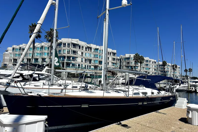 Dionysus Yacht Photos Pics 2003 Beneteau Oceanis Clipper 473 sailboat docked in marina, modern buildings in background.