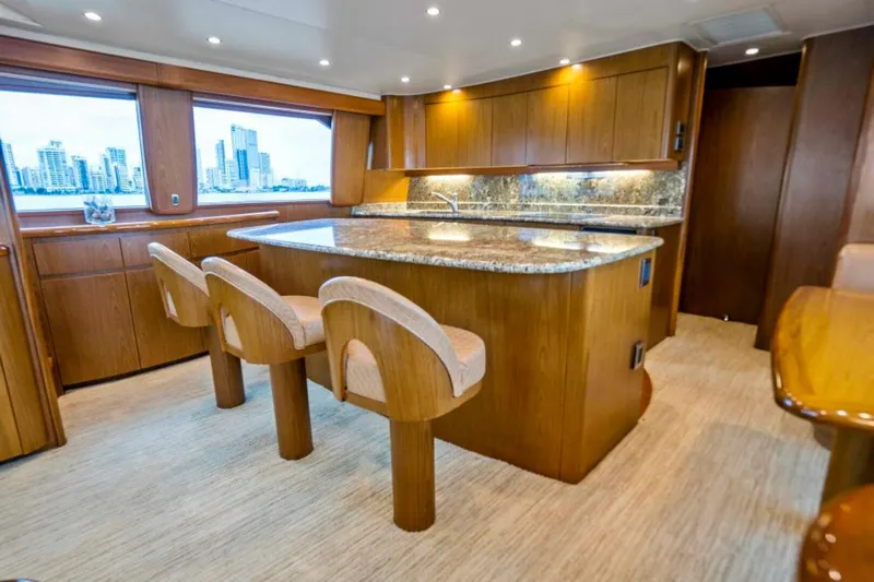 Last Call Yacht Photos Pics Luxurious interior of 2011 Viking 70 Enclosed Bridge yacht with modern kitchen and seating.