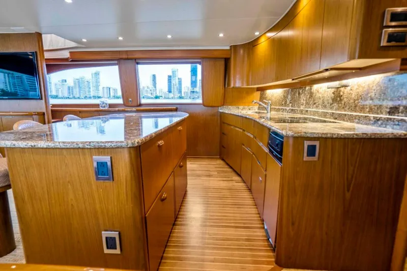 Last Call Yacht Photos Pics Luxurious kitchen interior of 2011 Viking 70 Enclosed Bridge yacht with wood cabinetry and granite countertops.