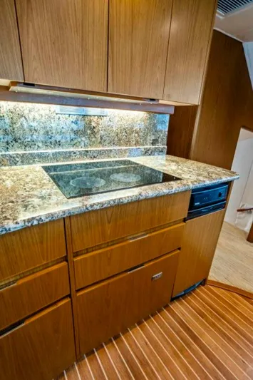 Last Call Yacht Photos Pics 2011 Viking 70 Enclosed Bridge kitchen with granite countertops and wood cabinetry.
