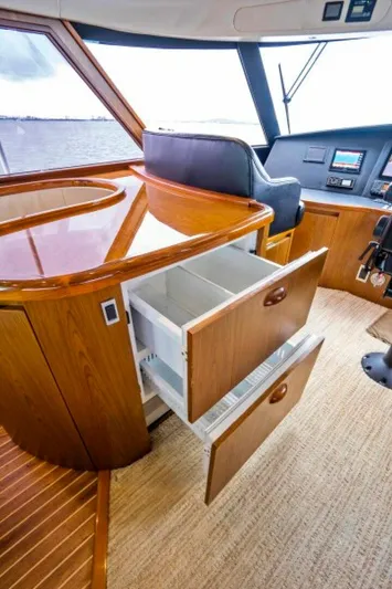 Last Call Yacht Photos Pics 2011 Viking 70 Enclosed Bridge interior with open wooden drawers and helm station.