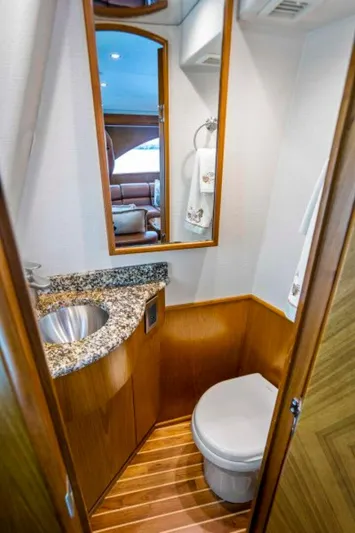Last Call Yacht Photos Pics Luxurious bathroom in 2011 Viking 70 Enclosed Bridge yacht with granite countertop and wood accents.