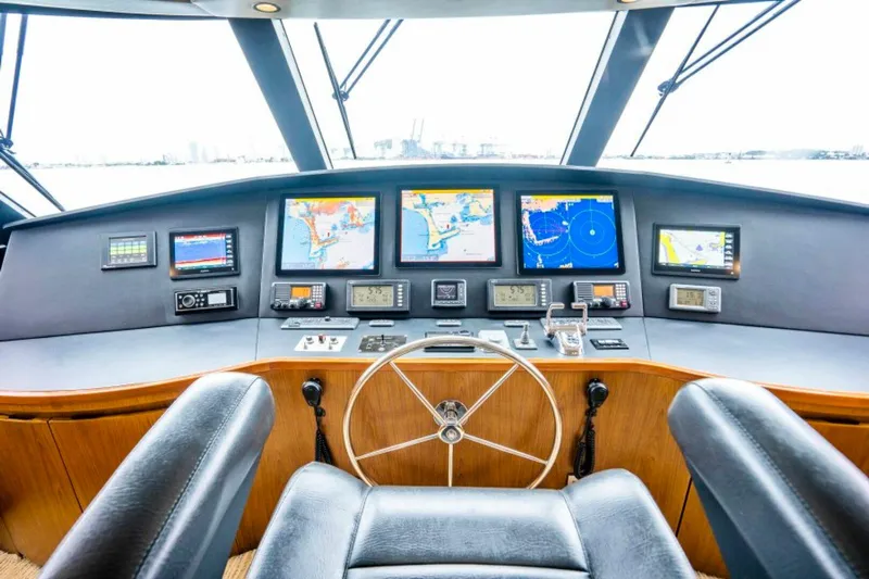 Last Call Yacht Photos Pics Cockpit of 2011 Viking 70 Enclosed Bridge yacht with navigation screens and steering wheel.