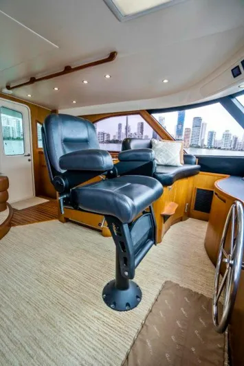 Last Call Yacht Photos Pics Interior of 2011 Viking 70 Enclosed Bridge yacht with luxurious seating and city skyline view.