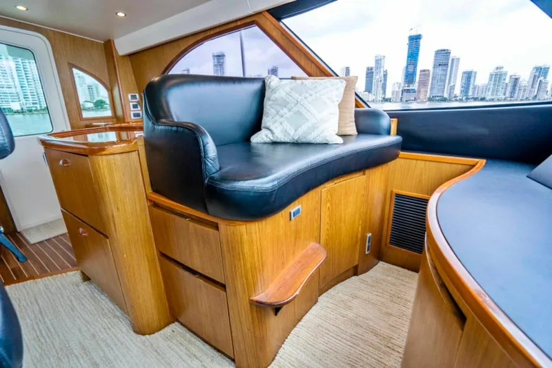 Last Call Yacht Photos Pics Luxurious interior of 2011 Viking 70 Enclosed Bridge yacht with leather seating and city skyline view.