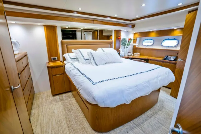 Last Call Yacht Photos Pics Luxurious bedroom interior of 2011 Viking 70 Enclosed Bridge yacht with elegant wood finish.