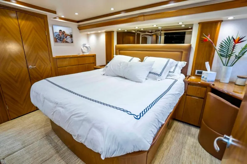 Last Call Yacht Photos Pics Luxurious bedroom interior of 2011 Viking 70 Enclosed Bridge yacht with elegant wood finishes.