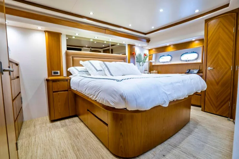 Last Call Yacht Photos Pics Luxurious bedroom interior of 2011 Viking 70 Enclosed Bridge yacht with elegant wood finishes.