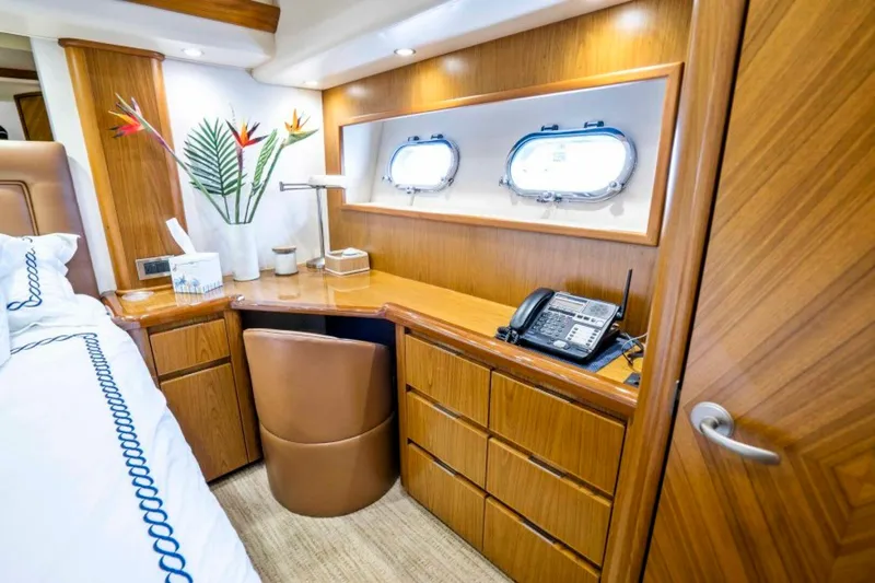 Last Call Yacht Photos Pics Luxurious cabin interior of 2011 Viking 70 Enclosed Bridge yacht with desk and portholes.