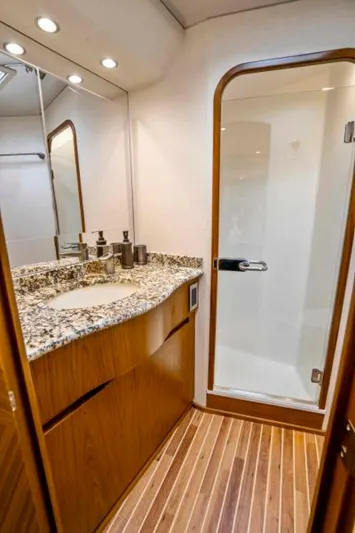 Last Call Yacht Photos Pics Luxurious bathroom in 2011 Viking 70 Enclosed Bridge yacht with granite countertop and wooden flooring.