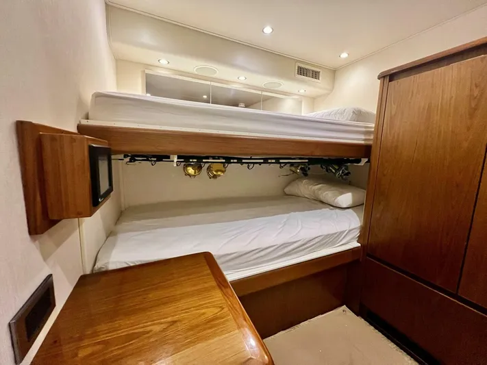 Last Call Yacht Photos Pics Interior of 2011 Viking 70 Enclosed Bridge yacht with bunk beds and wooden cabinetry.