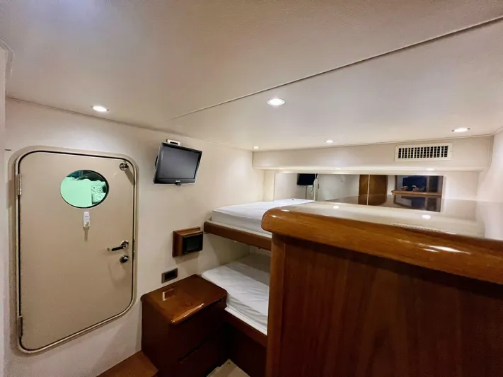 Last Call Yacht Photos Pics Interior cabin of 2011 Viking 70 Enclosed Bridge yacht with bunk beds and TV.