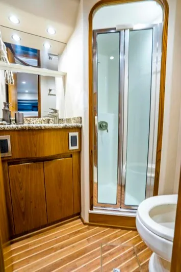 Last Call Yacht Photos Pics Luxurious bathroom in 2011 Viking 70 Enclosed Bridge yacht with wood accents and modern fixtures.