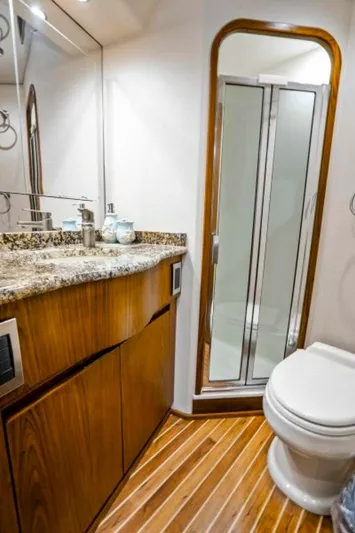 Last Call Yacht Photos Pics Luxurious bathroom in 2011 Viking 70 Enclosed Bridge yacht with granite countertop and wood accents.