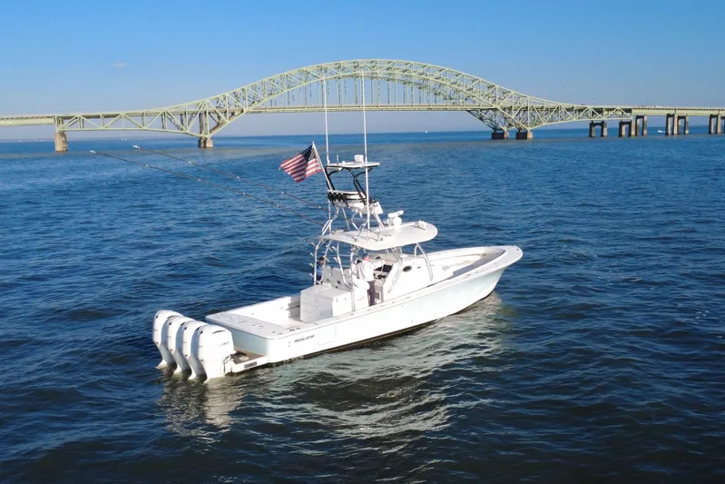  Yacht Photos Pics 2016 Regulator 41 boat on water near a bridge, with American flag.