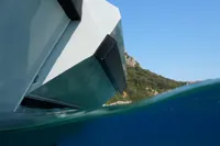 Seanfinity T5 boat partially submerged in clear blue water, with a scenic coastline in the background.