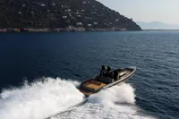 Seanfinity T5 2021 speedboat cruising on open water near a rocky coastline.