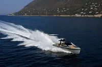 Seanfinity T5 2021 speedboat cruising on open water near a mountainous coastline.