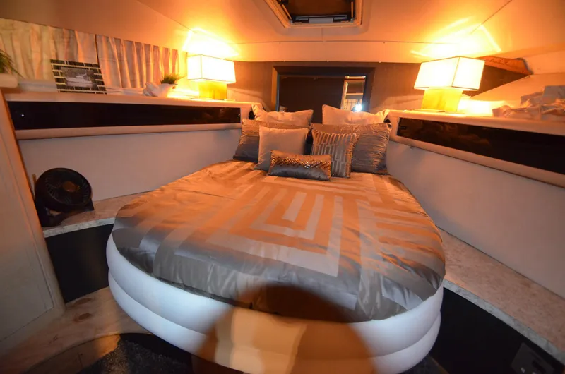 Suite Forty Six Yacht Photos Pics Luxurious cabin interior of 1989 Silverton Aft Cabin 46 yacht with cozy bedding and ambient lighting.
