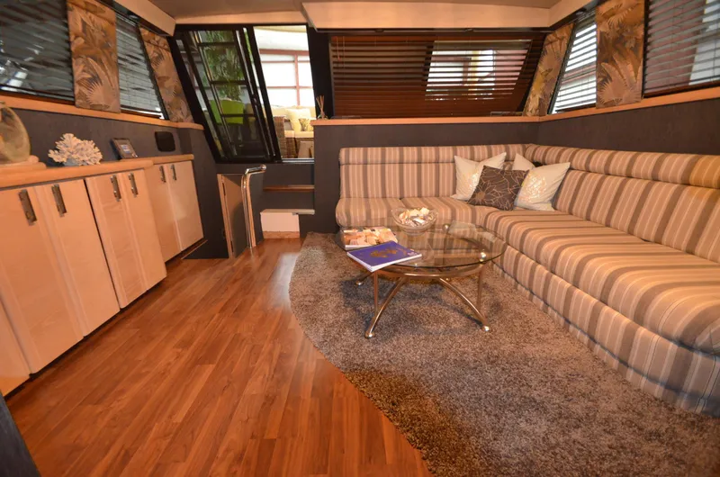 Suite Forty Six Yacht Photos Pics 1989 Silverton Aft Cabin 46 interior with striped sofa, glass table, and wood flooring.