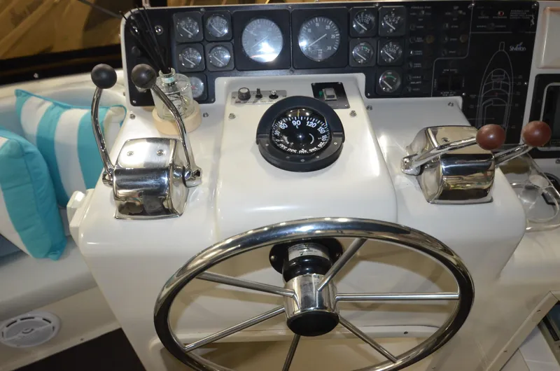Suite Forty Six Yacht Photos Pics Control panel of a 1989 Silverton Aft Cabin 46 yacht with steering wheel and gauges.