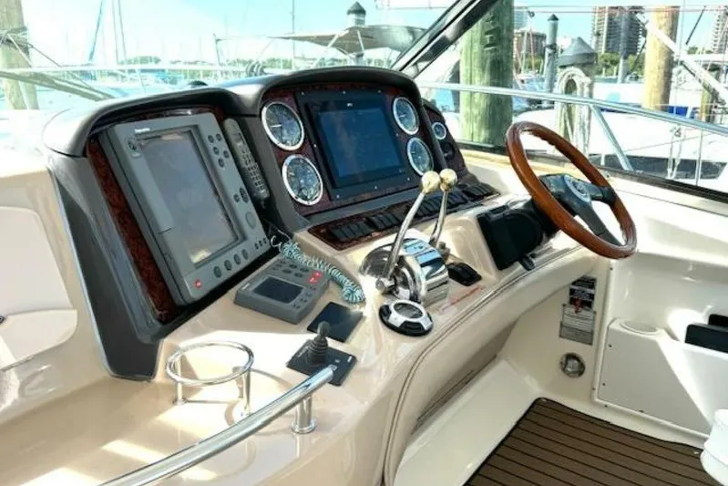  Yacht Photos Pics Helm of 2003 Sea Ray 420 Sundancer with navigation equipment and wooden steering wheel.