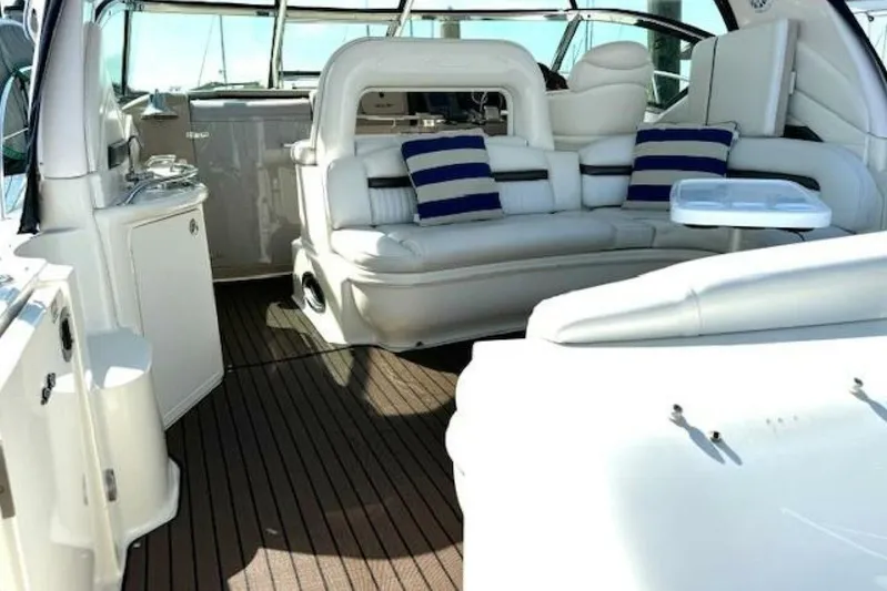  Yacht Photos Pics Luxurious interior of 2003 Sea Ray 420 Sundancer yacht with white seating and striped cushions.