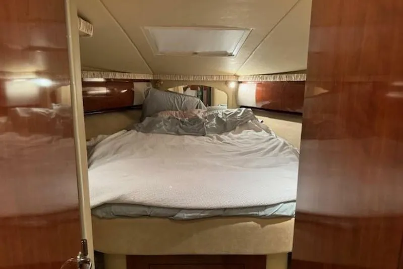  Yacht Photos Pics Interior cabin of 2003 Sea Ray 420 Sundancer with cozy bed and wooden finish.