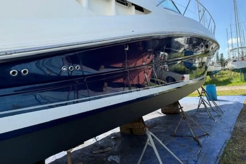  Yacht Photos Pics 2003 Sea Ray 420 Sundancer yacht on stands, reflecting surroundings, under clear blue sky.