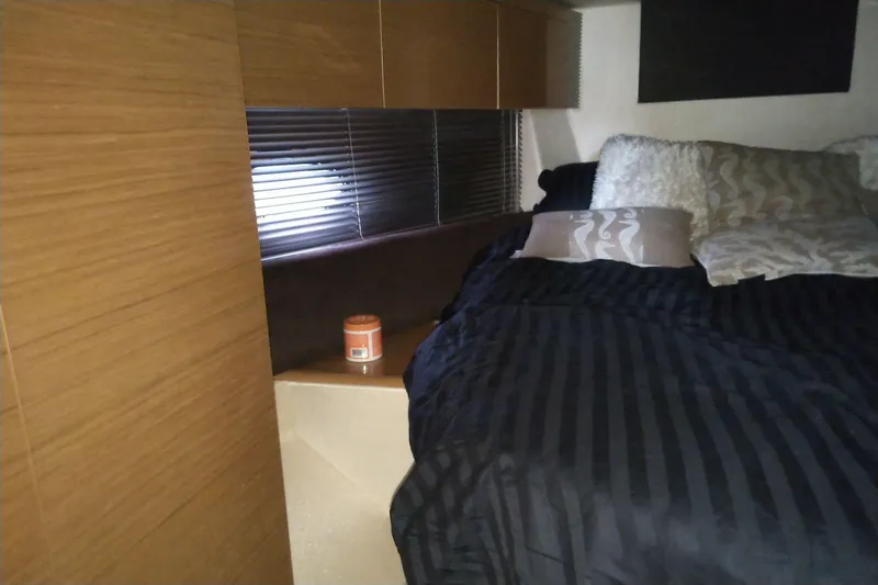 Sol Yacht Photos Pics Cozy bedroom interior of 2010 Azimut Atlantis 54 yacht with striped bedding and pillows.
