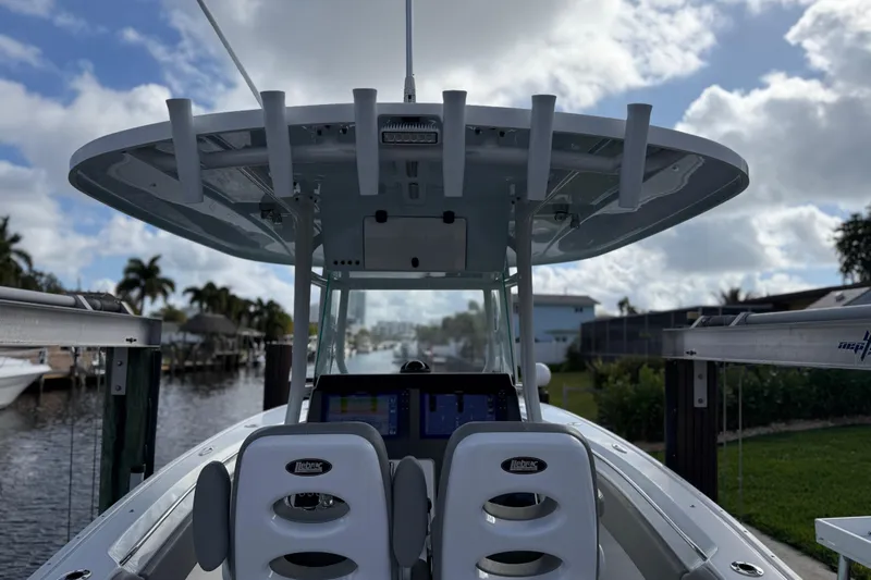  Yacht Photos Pics 2023 Cape Horn 32 XS boat interior with helm and seating, docked by a canal.