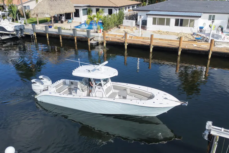  Yacht Photos Pics 2023 Cape Horn 32 XS boat cruising in a calm marina with waterfront homes.