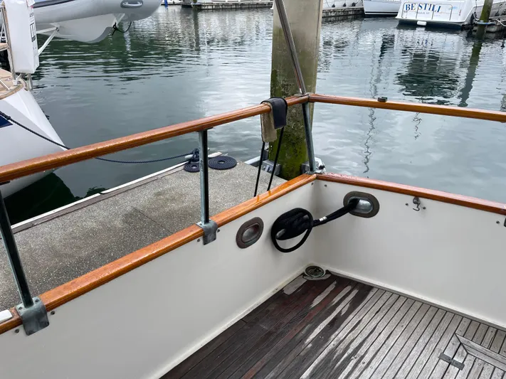  Yacht Photos Pics 1980 Grand Banks 42 Europa boat deck with wooden railings at a marina.