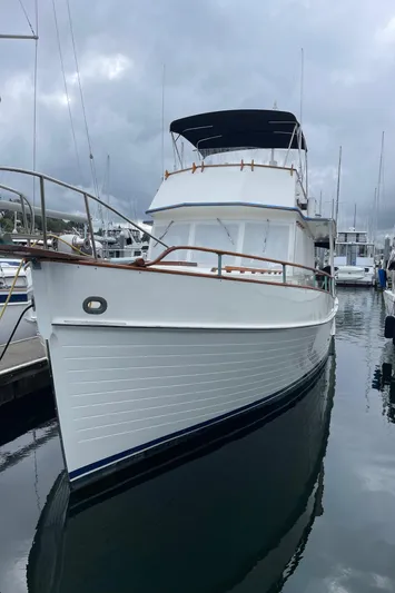  Yacht Photos Pics 1980 Grand Banks 42 Europa yacht docked in a marina under cloudy skies.