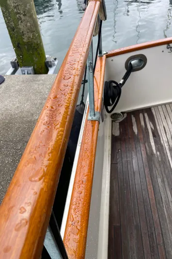  Yacht Photos Pics Close-up of 1980 Grand Banks 42 Europa boat deck with wet wooden railing.